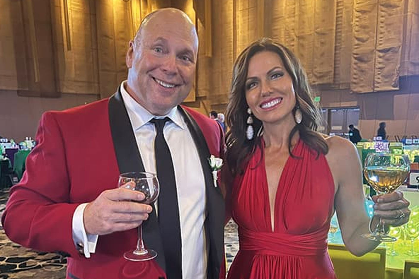 A man and women smiling hold onto drinks