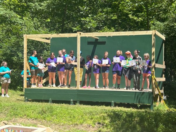 Girl Scouts standing on an outdoor stage.